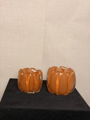 Amberkleurige glazen waxinelichthouders in groot en klein formaat.